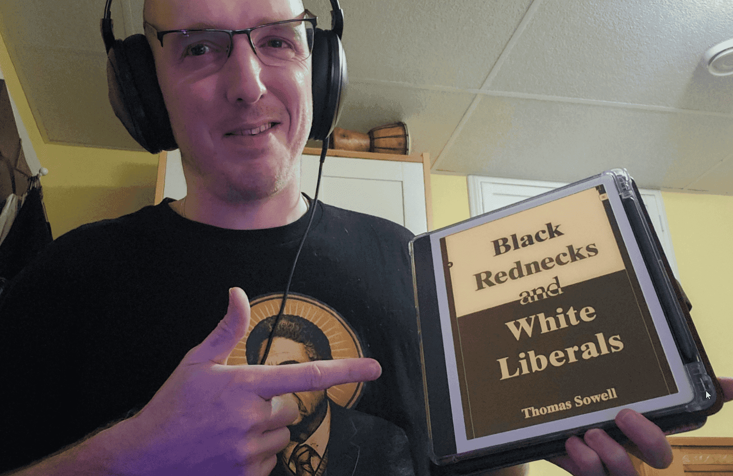 Clay holding Black Rednecks and White Liberals by Thomas Sowell
